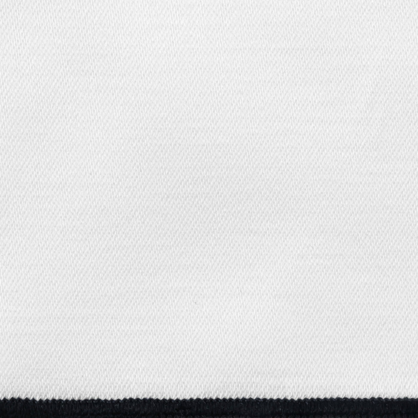 Close-up of white woven linen fabric with a black border edge visible at bottom.