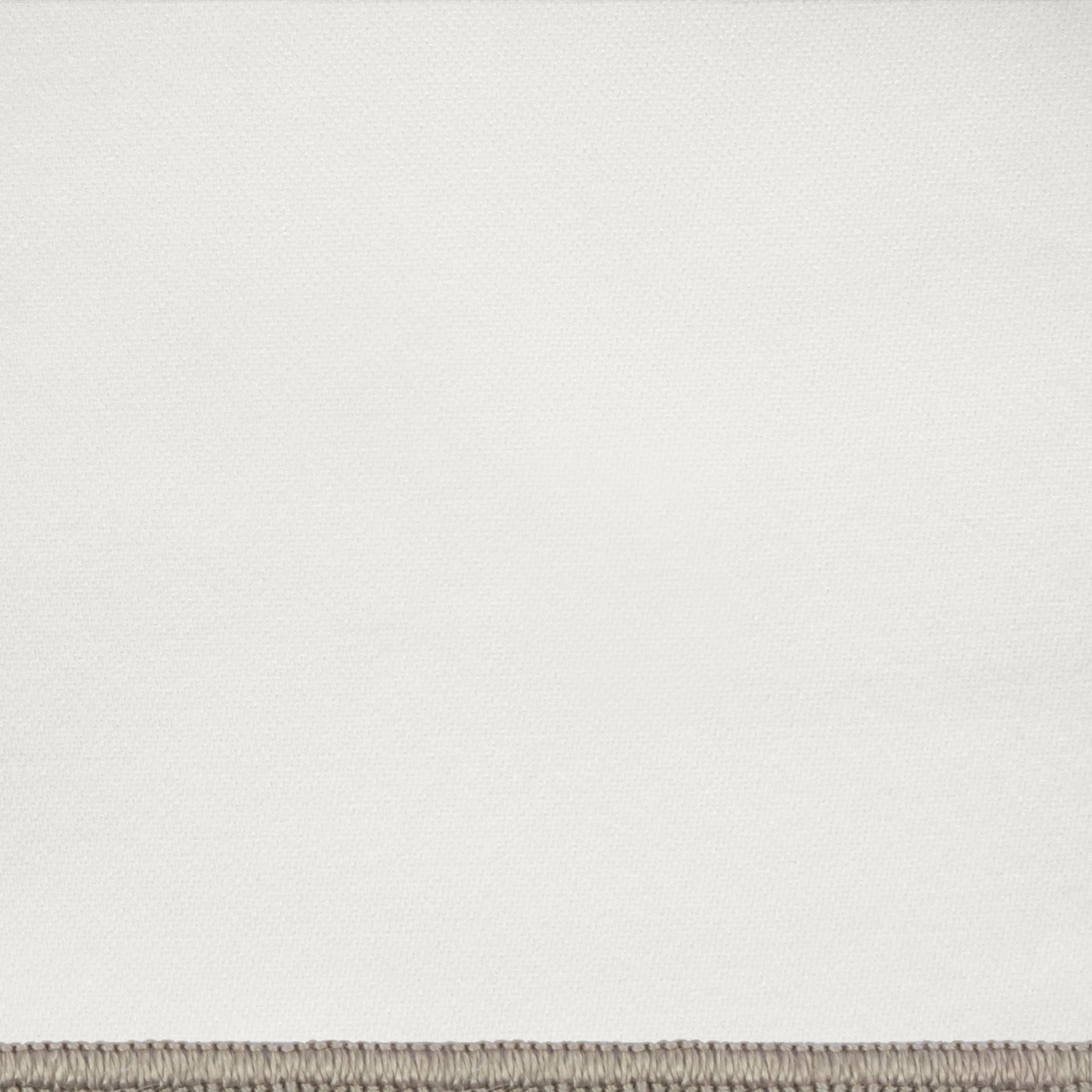Close-up of ivory linen fabric with taupe blanket-stitch border detail.