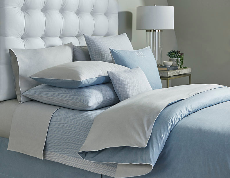 Close-up styled bed with Home Treasures Asher bedding in sky blue and silver grey.