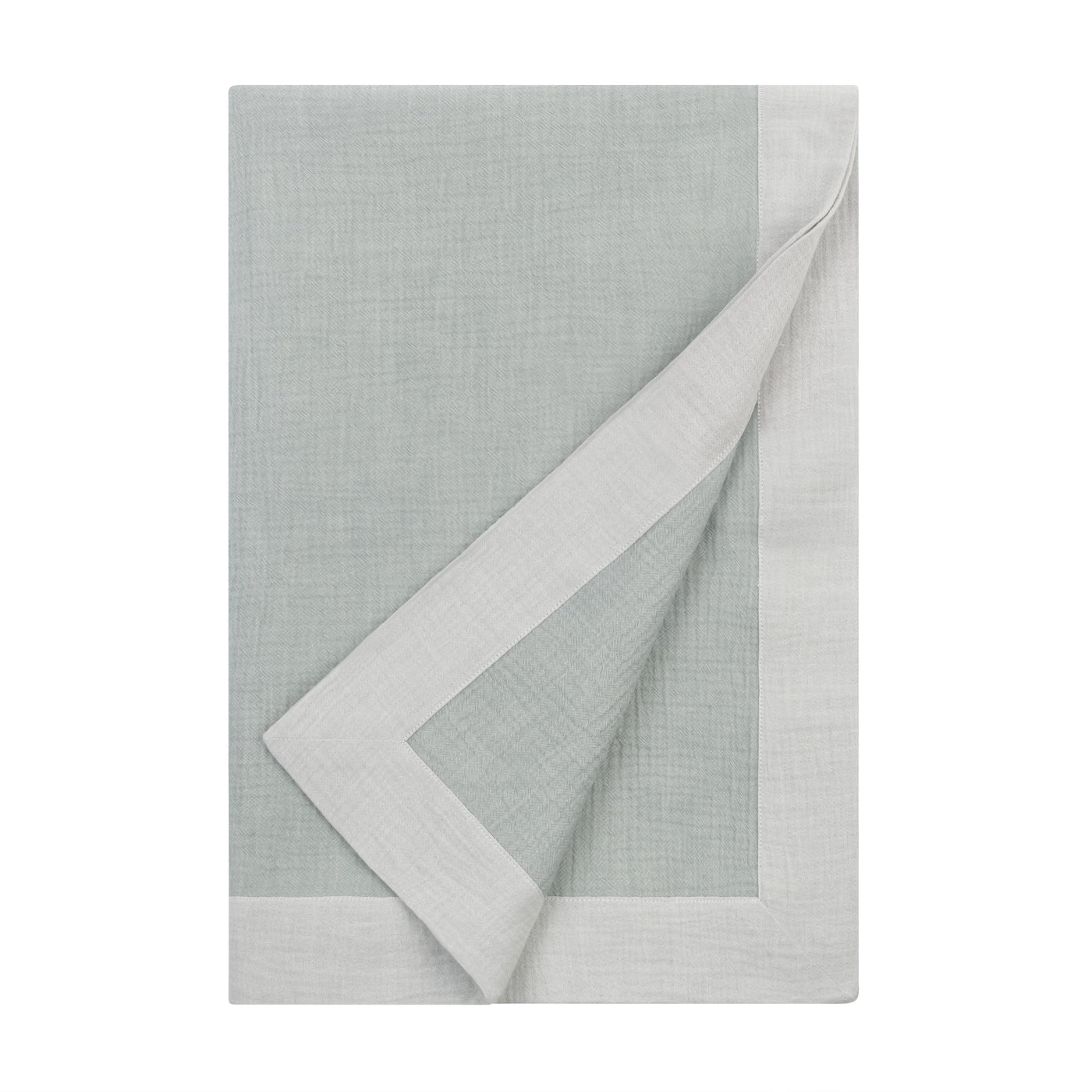 Corner fold detail revealing ivory reverse of Home Treasures Atacama throw in sage linen.