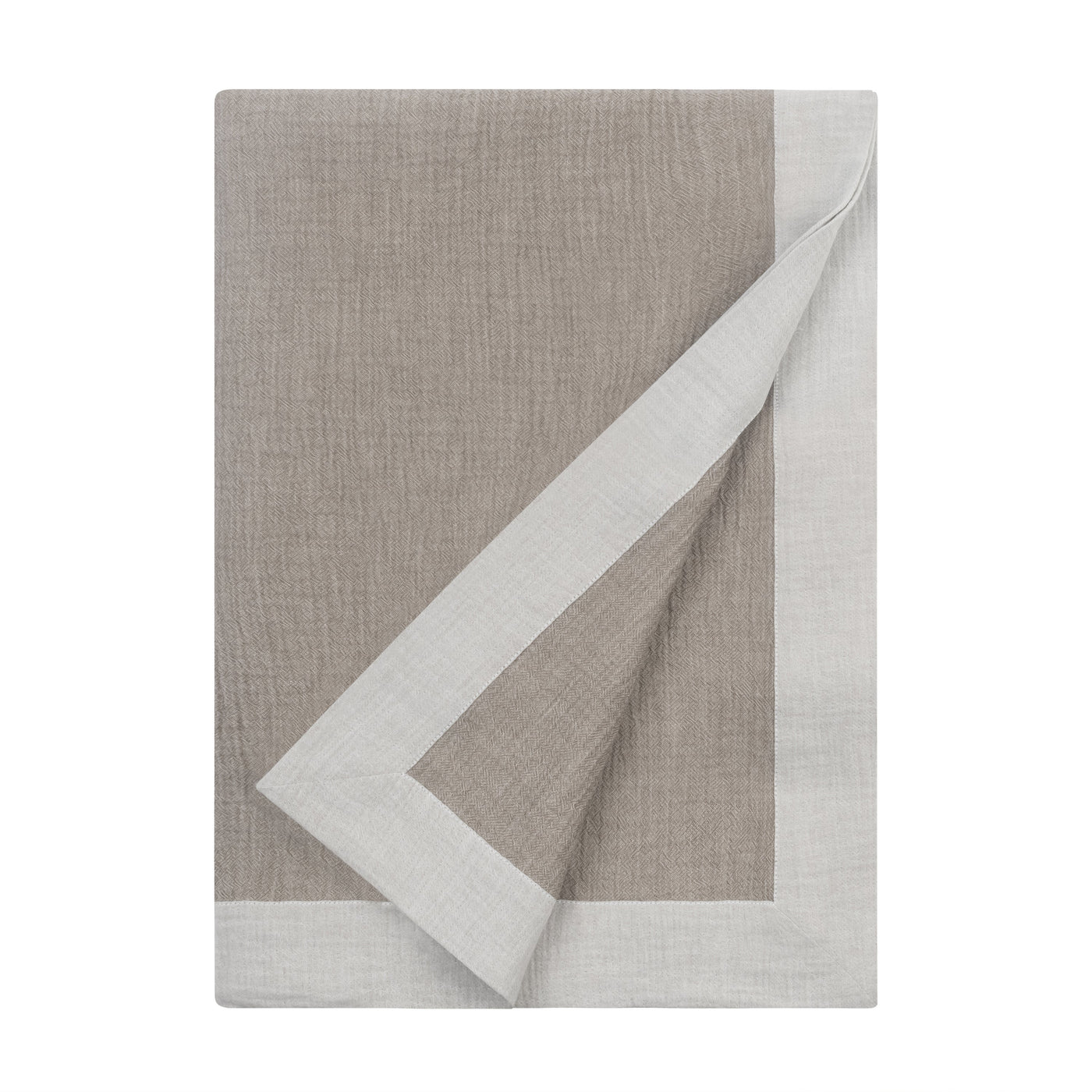 Corner fold detail revealing ivory mitered border contrast on taupe linen Atacama throw.