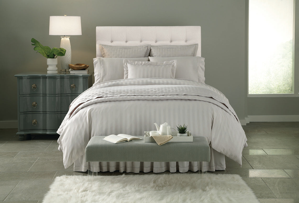 Pearl damask stripe bedding set styled on a bed in a soft grey bedroom.