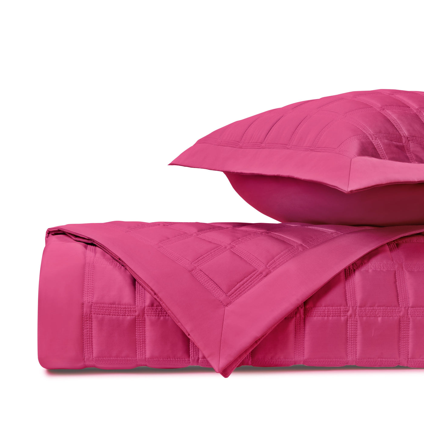 Close-up of fuchsia quilted cotton coverlet and sham with grid-stitch pattern.