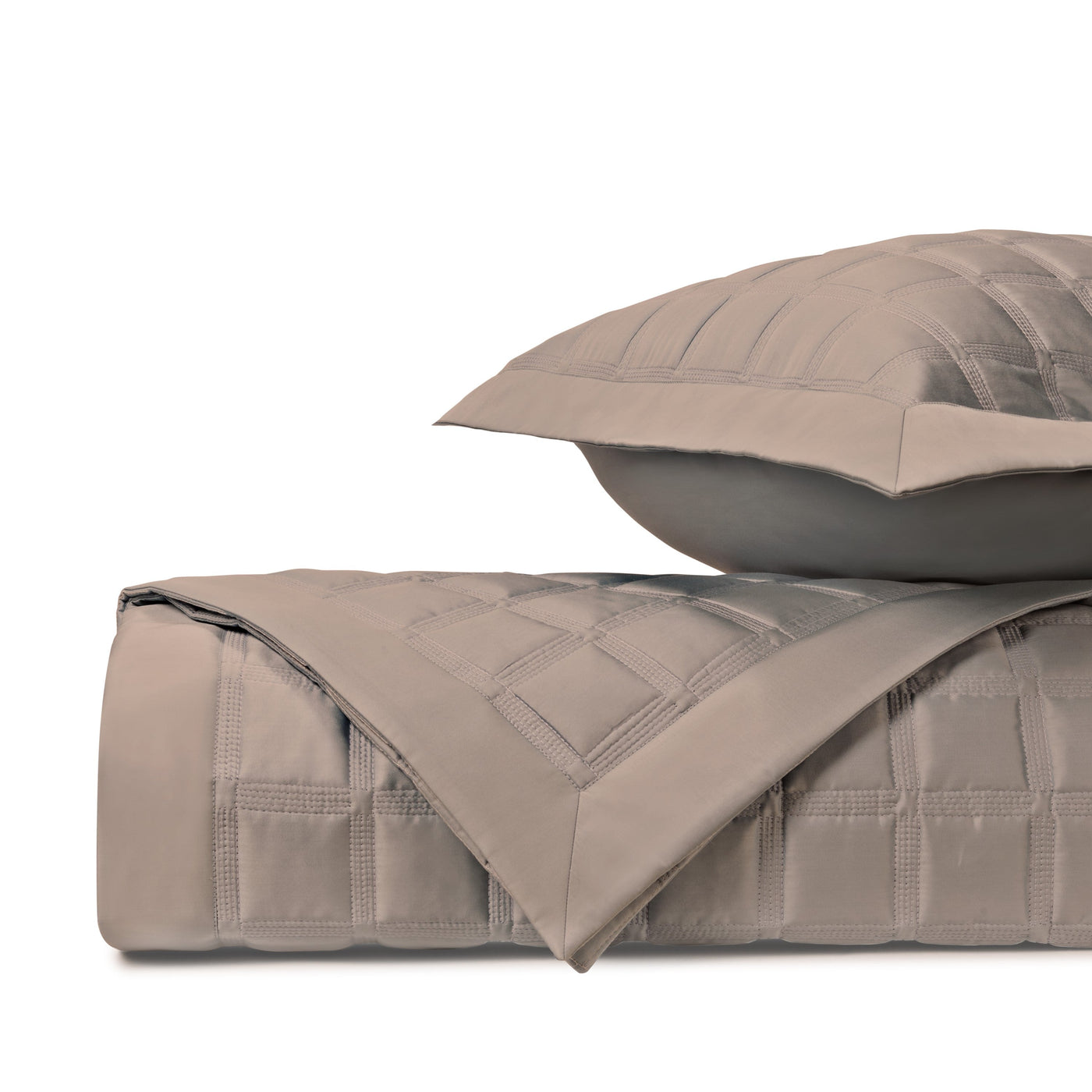 Folded Athens quilted coverlet and sham in taupe, showing grid-stitched texture detail.