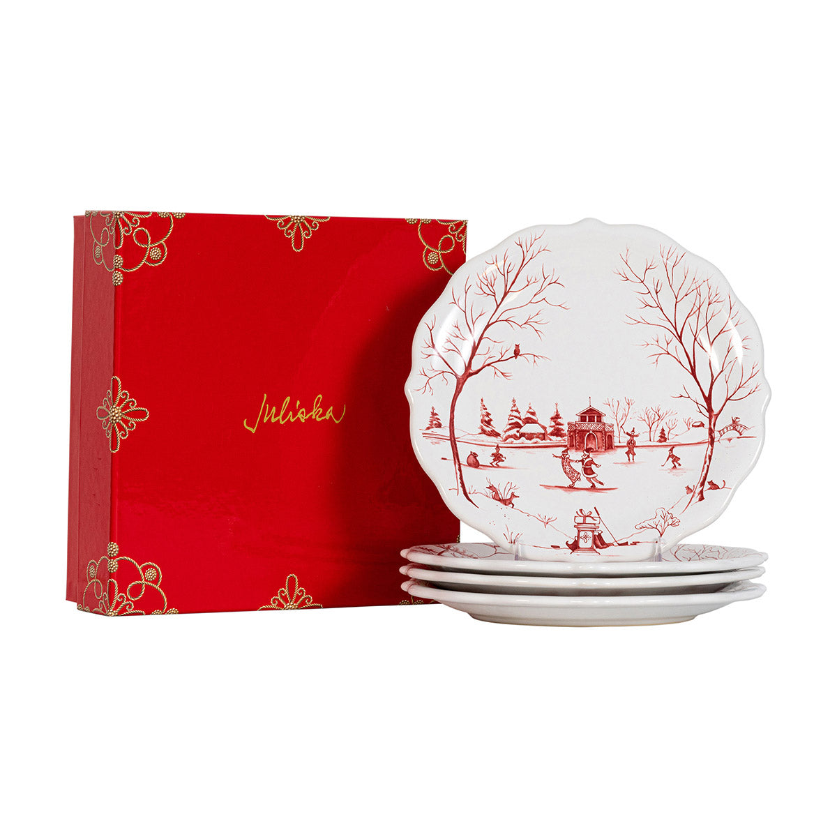 Stack of ruby Winter Frolic party plates beside a red Juliska gift box