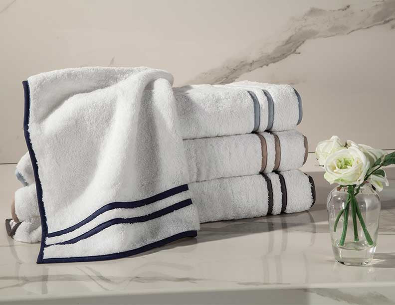 Close-up of Home Treasures Ribbons towels in white with navy and taupe stripe borders.