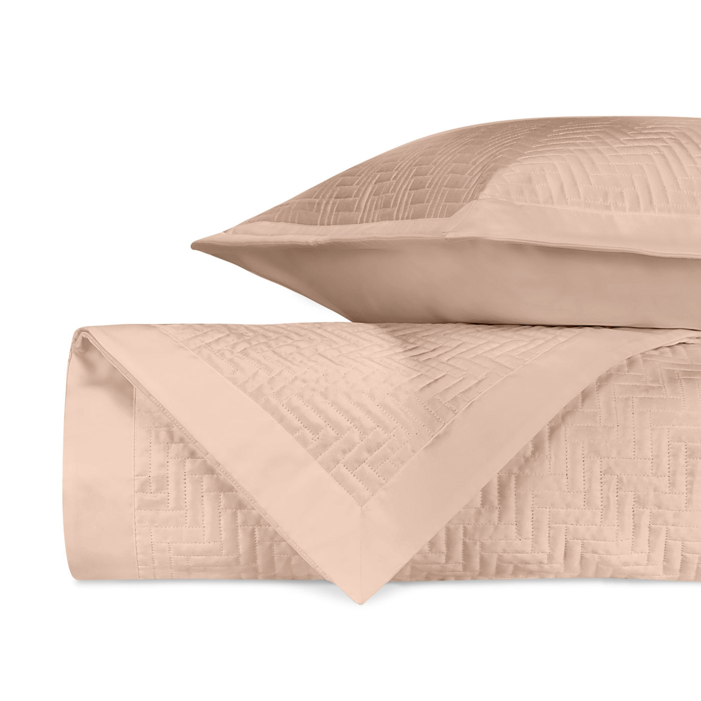 Close-up of Baxter quilted coverlet in blush with geometric herringbone stitch detail.
