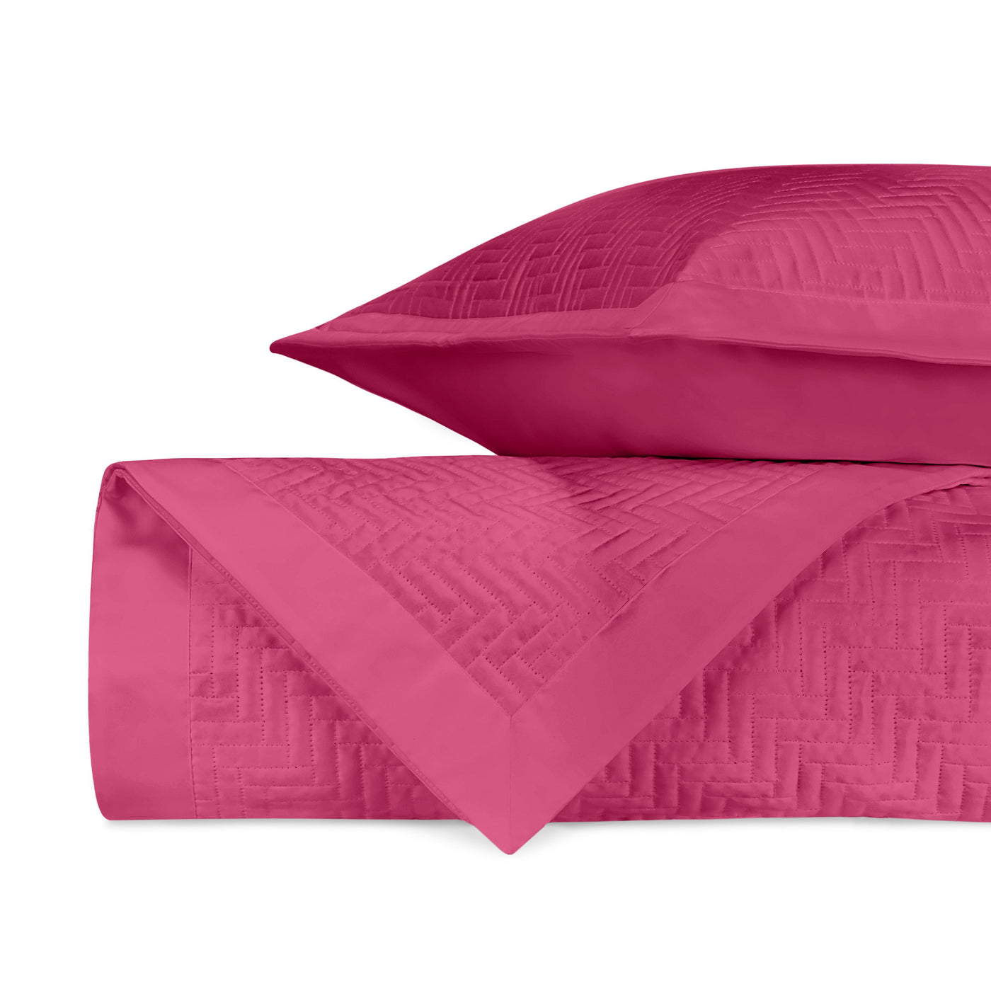 Close-up of fuchsia quilted fabric with woven geometric pattern and border detail.