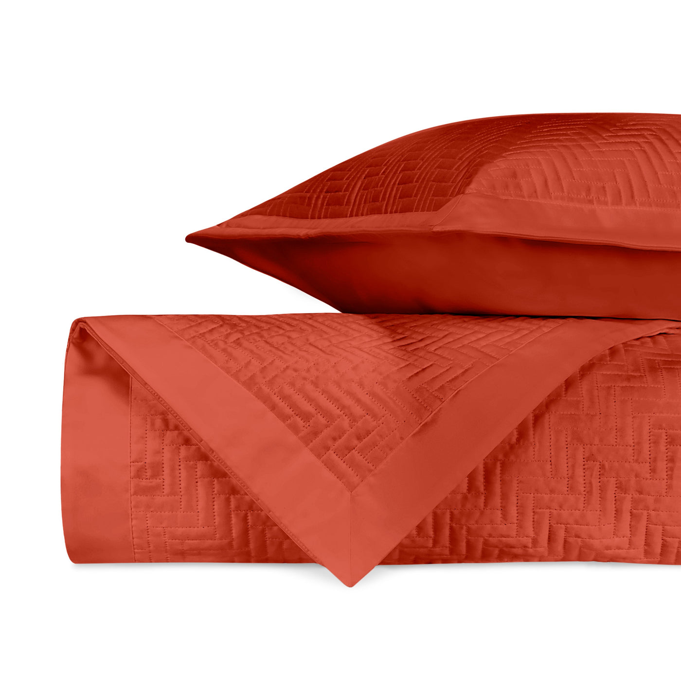 Close-up of Baxter quilted coverlet in terracotta with geometric basket-weave stitching detail.