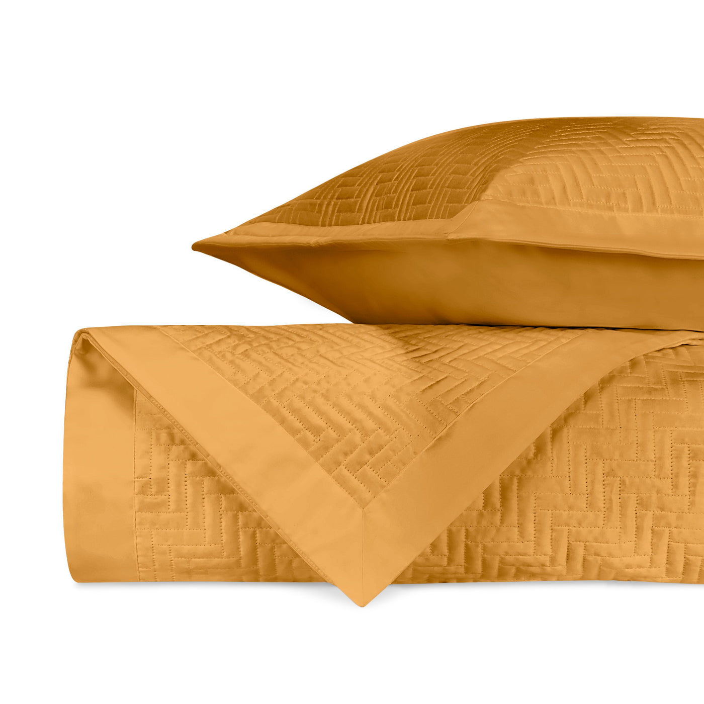 Saffron quilted coverlet and sham folded, showing geometric basketweave texture detail.