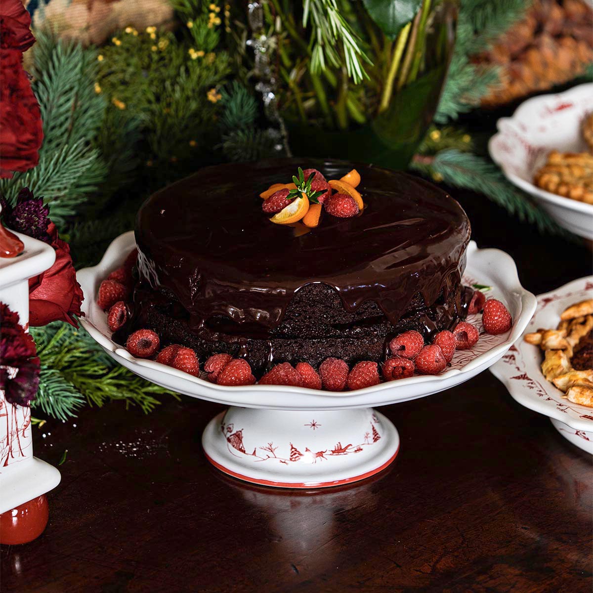 Chocolate cake with raspberries on a ruby Winter Frolic cake stand