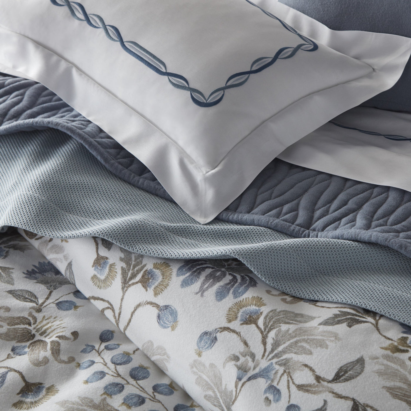 Close-up of layered Home Treasures Beatrice blue floral linen with quilted and embroidered accents.
