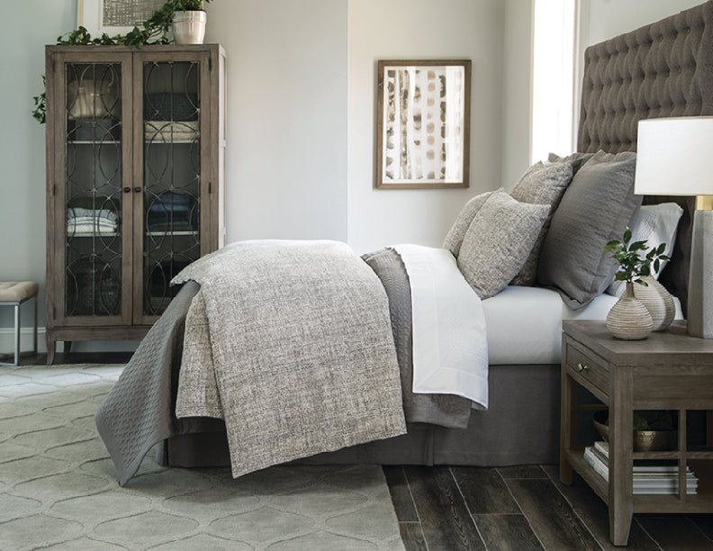 Styled bedroom featuring Home Treasures Coco bedding in soft grey tones with textured quilted coverlet.