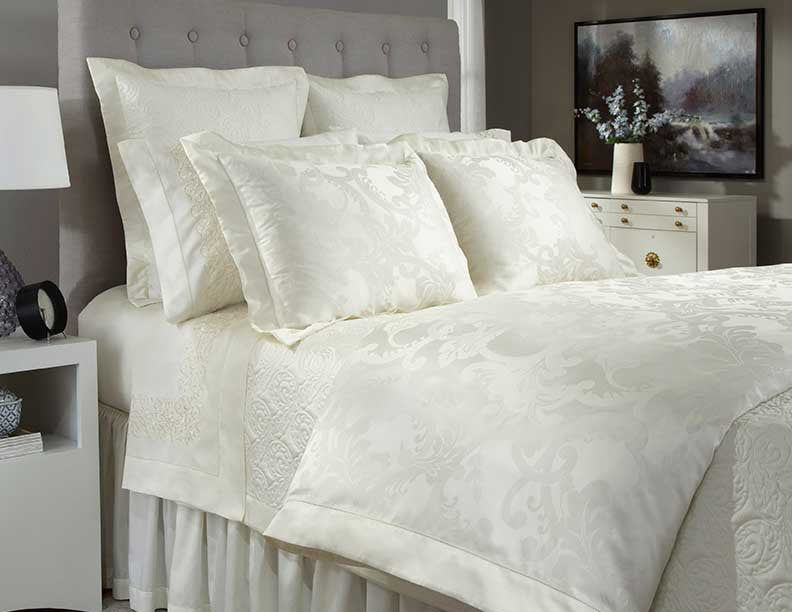 Home Treasures Darian ivory jacquard floral bedding styled on a dressed bed.