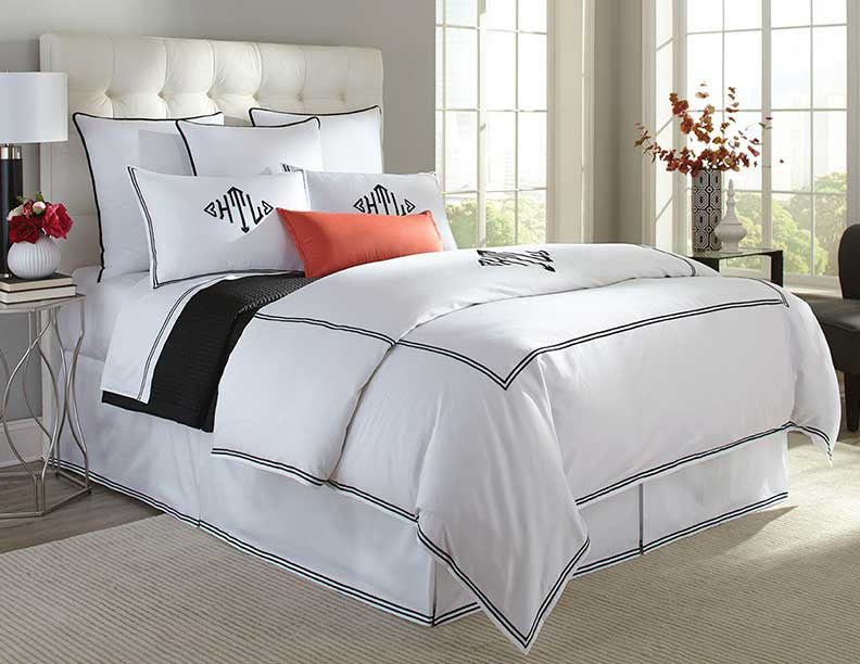 Home Treasures Madison white bedding with black border trim on a styled bed.