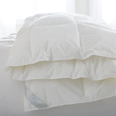 Scandia Home Bergen down-free duvet in white with baffle box stitching, folded on a bed.
