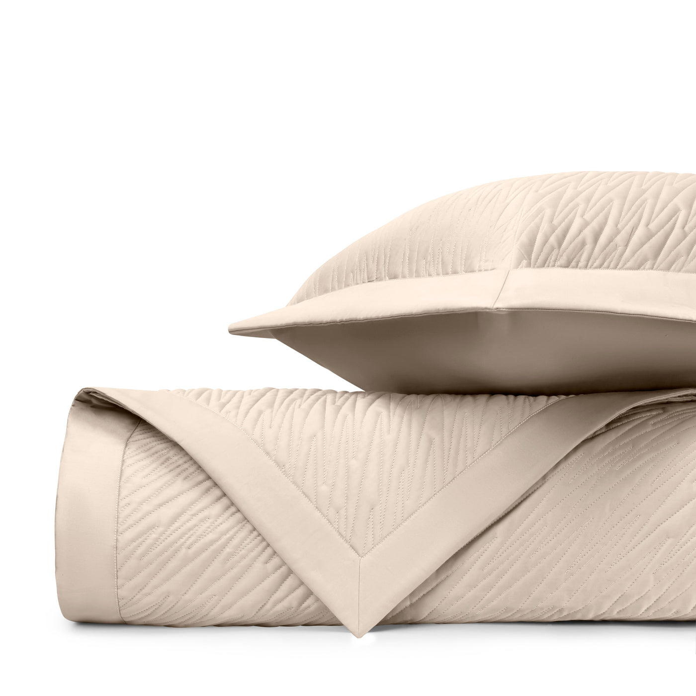 Close-up of ivory quilted texture with wave-pattern stitching and mitered border detail.