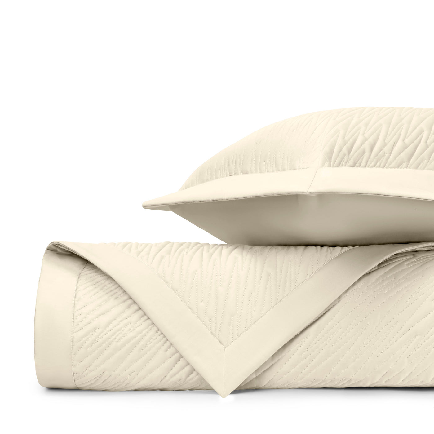 Close-up of ivory quilted texture with subtle wave stitching pattern and mitered border detail.