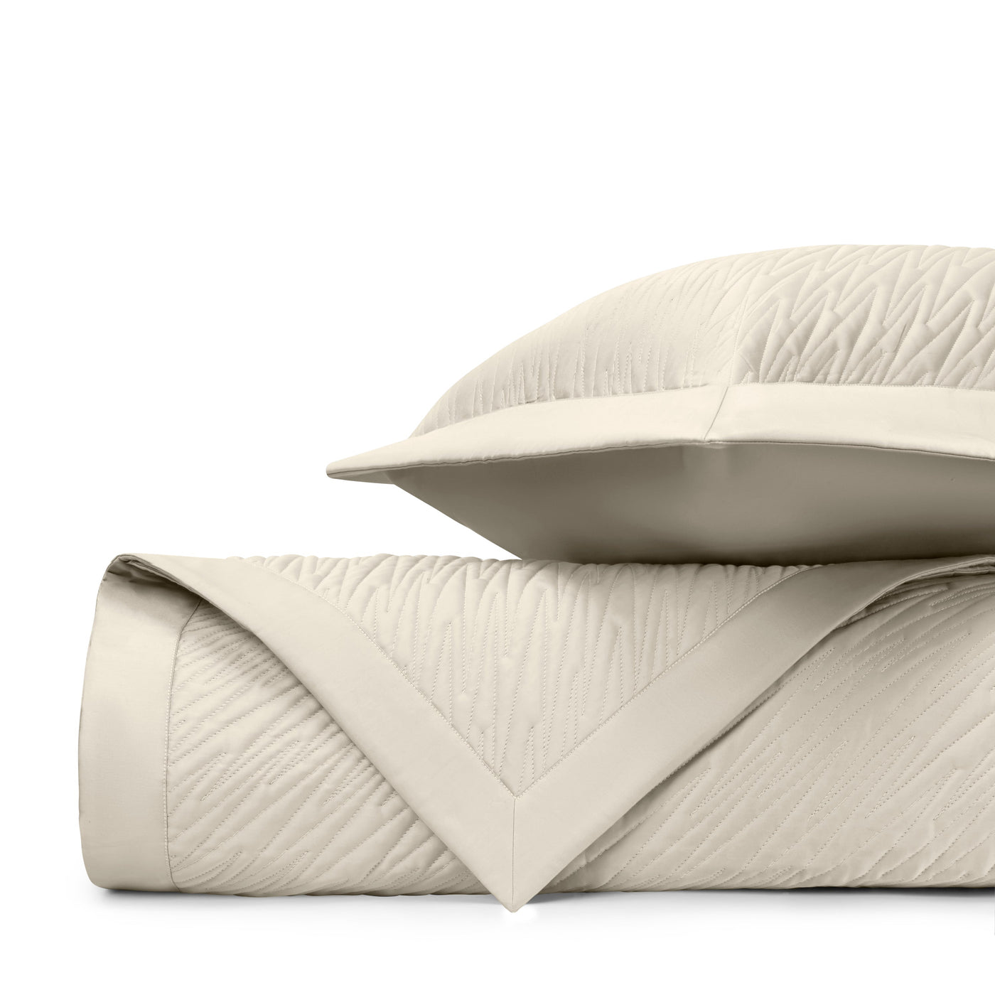 Close-up of ivory quilted fabric with subtle wave texture and contrast border trim.