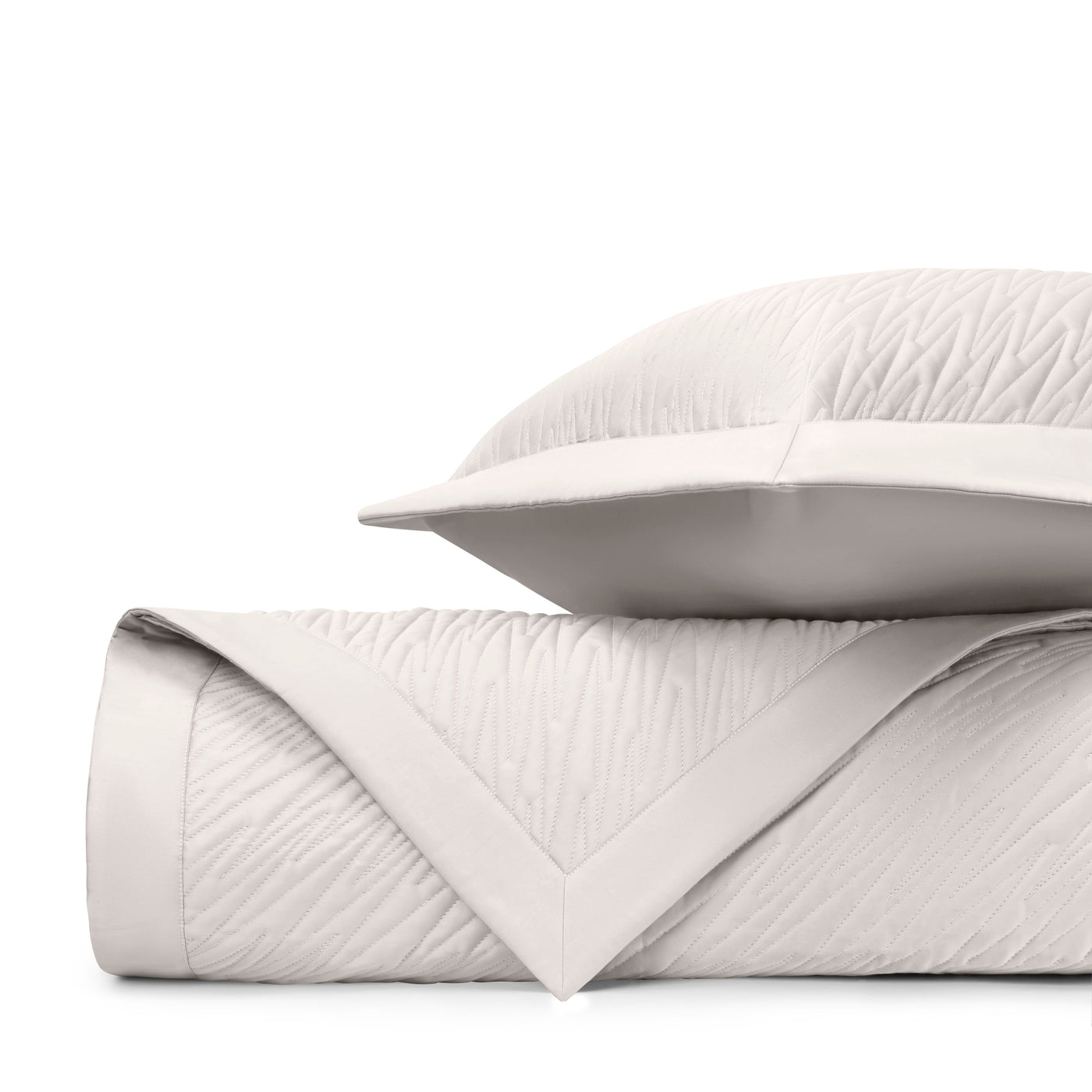 Close-up of ivory quilted texture with subtle wave pattern and satin border trim.