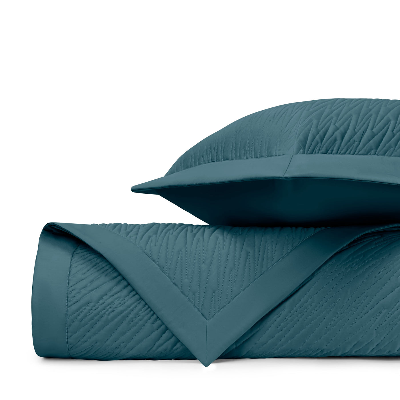 Teal quilted texture detail on folded Blaze coverlet with coordinating sham.