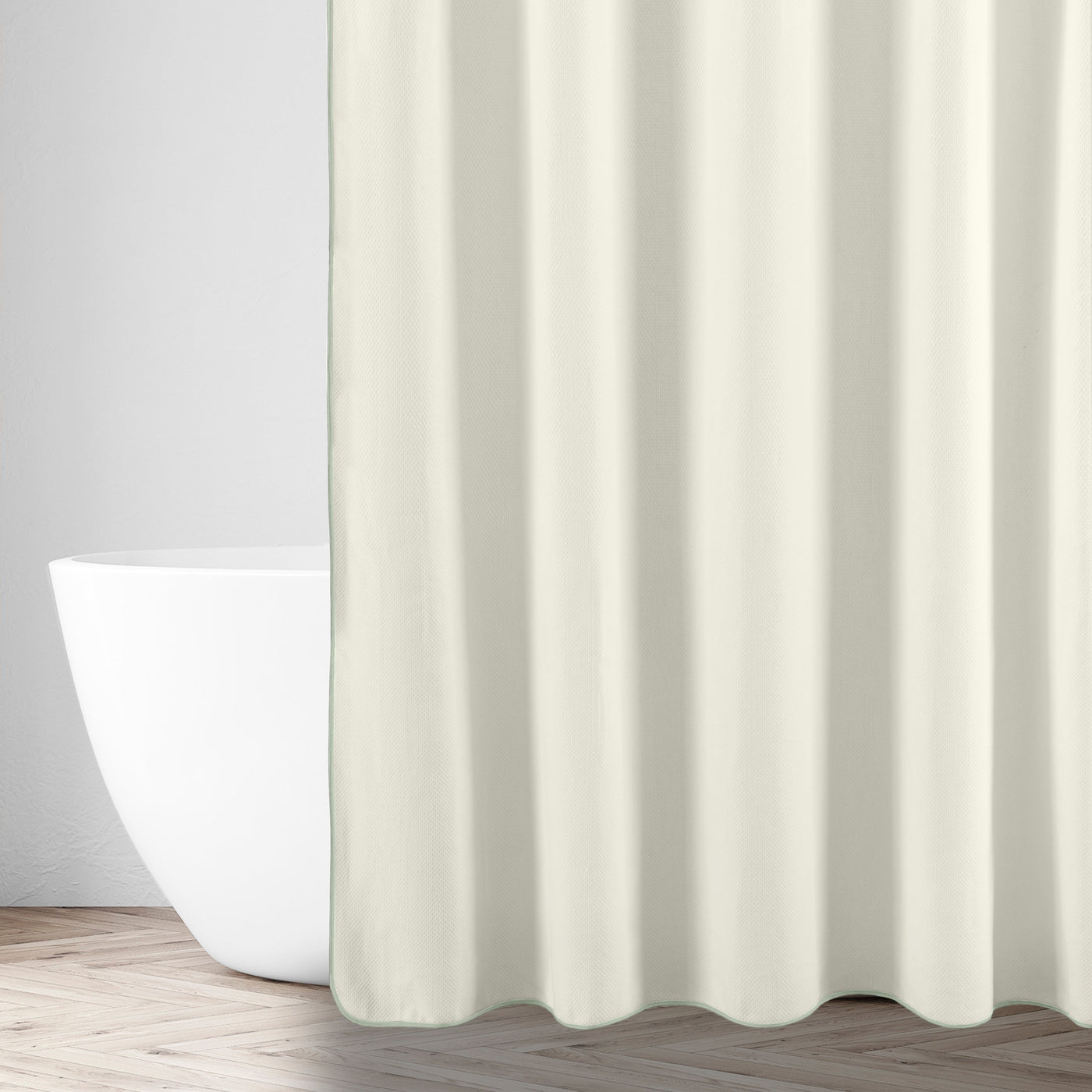 Ivory shower curtain draped in a bathroom setting beside a freestanding white tub.