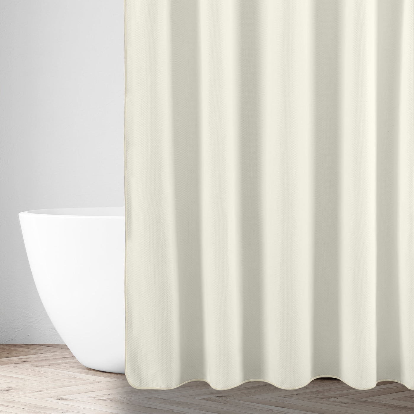 Ivory shower curtain styled in a bathroom setting beside a freestanding white tub.