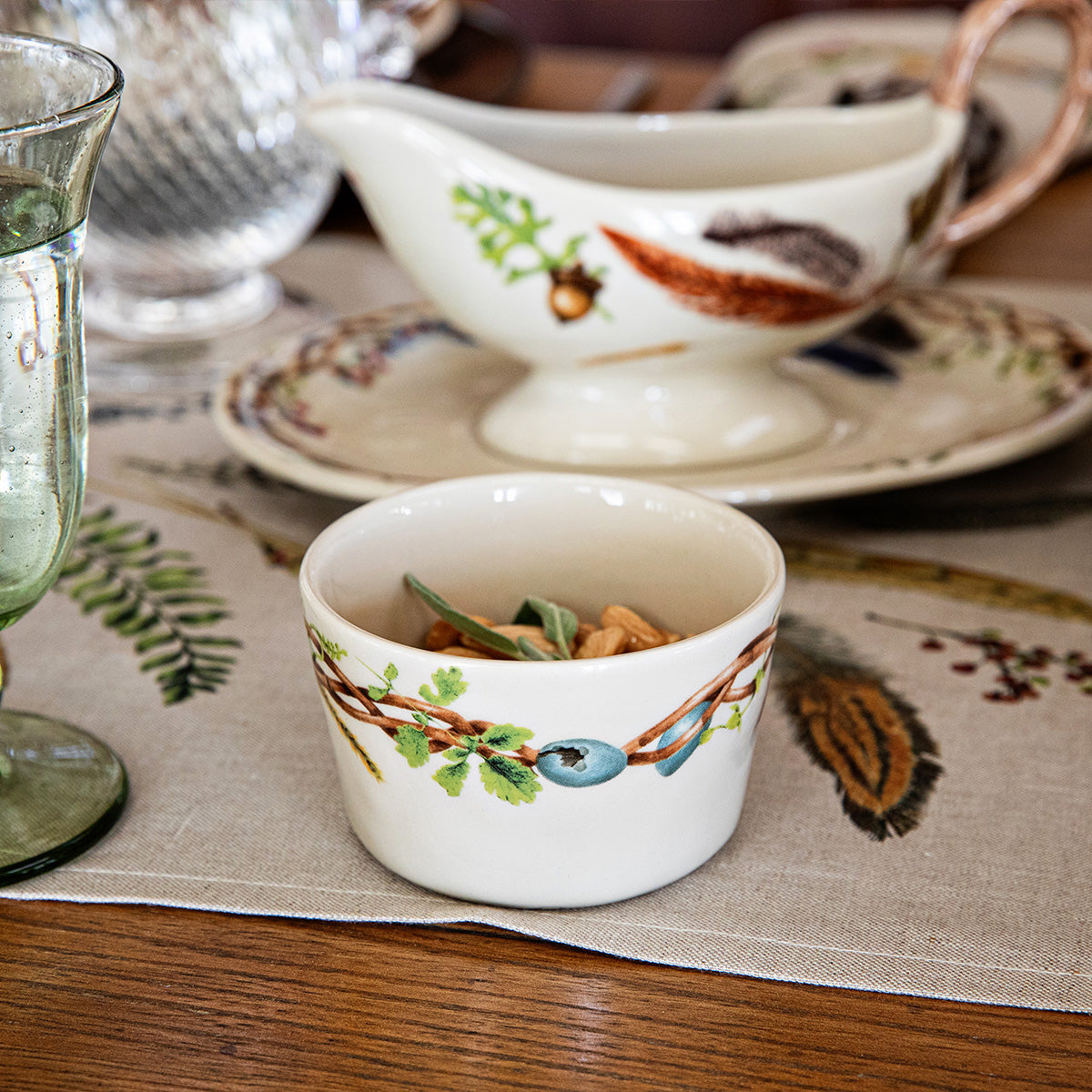 Forest Walk ramekin filled with food beside a sauce boat and plate on a linen table runner