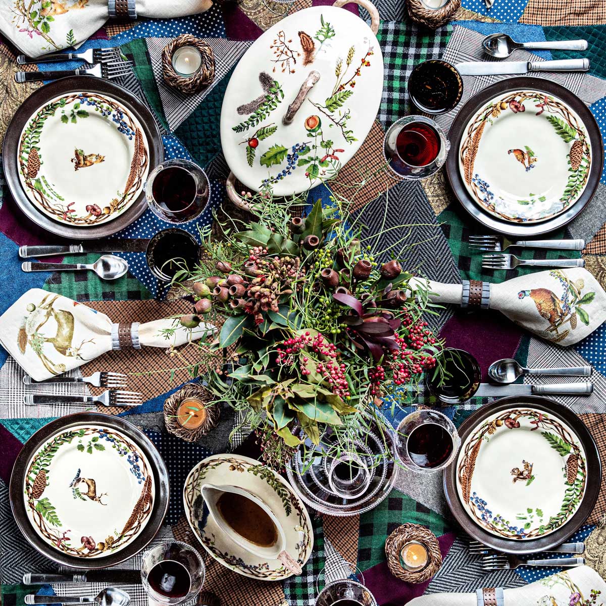Overhead of a plaid-covered table set with Forest Walk dinnerware around a greenery centerpiece