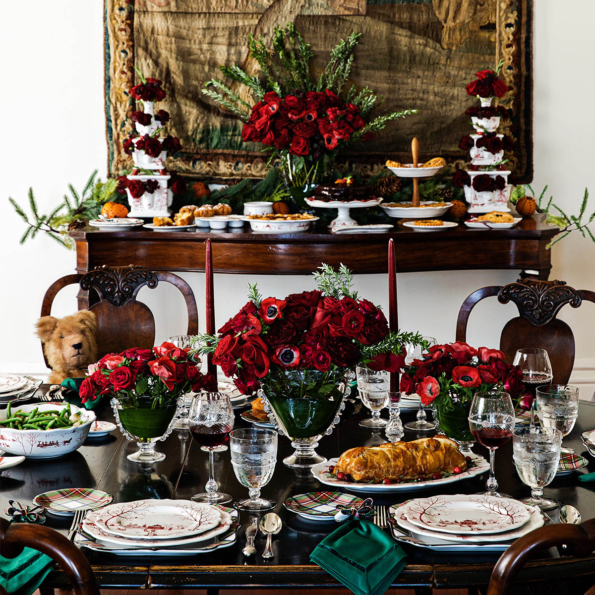 Holiday buffet with ruby Winter Frolic plates, red roses and silver serving pieces