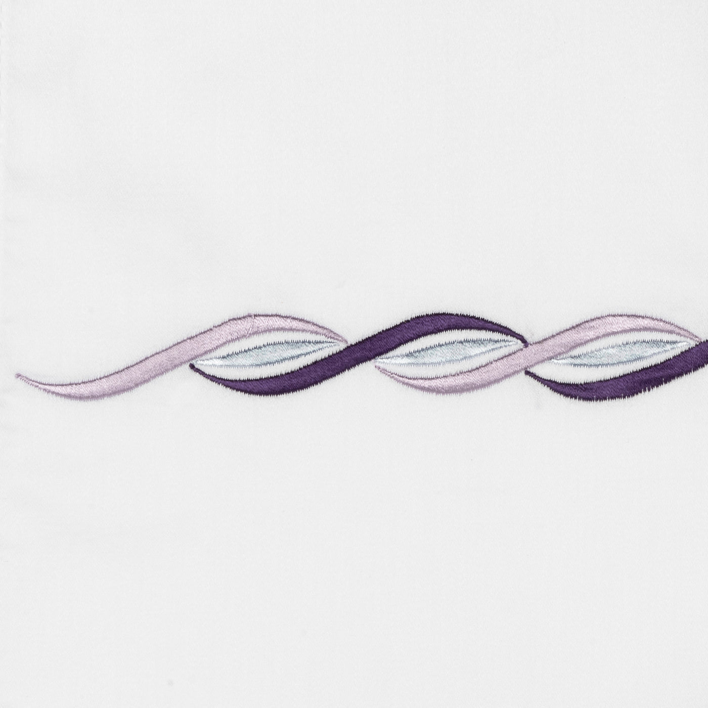 Close-up of violet and lavender embroidered ribbon motif on white linen.