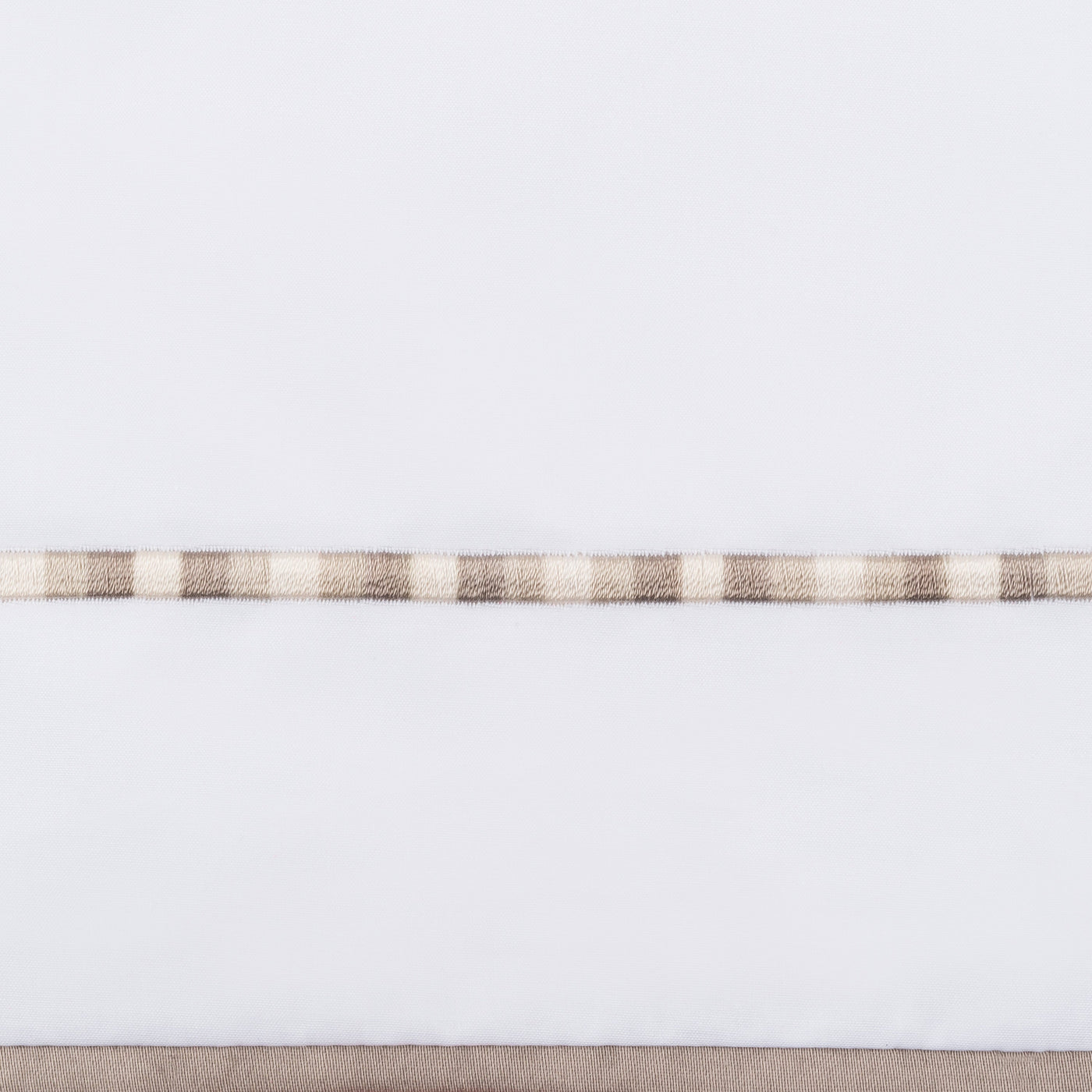 Close-up of Calypso flat sheet hem with woven taupe and ivory check trim detail.