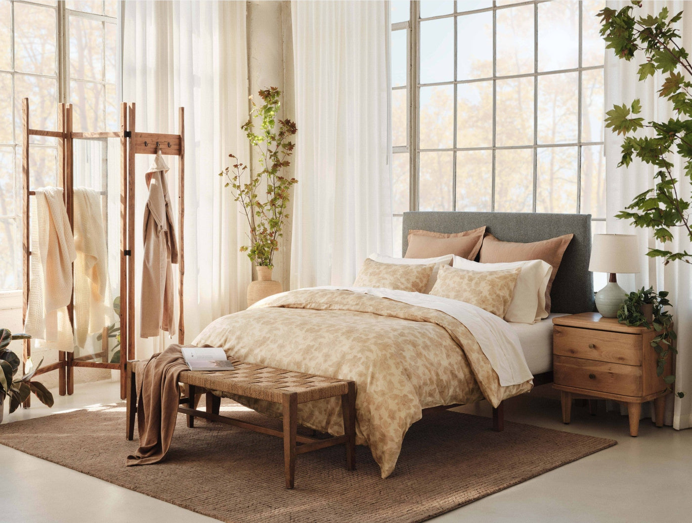Coyuchi Camellia Print duvet cover styled on bed in warm neutral bedroom with natural light.