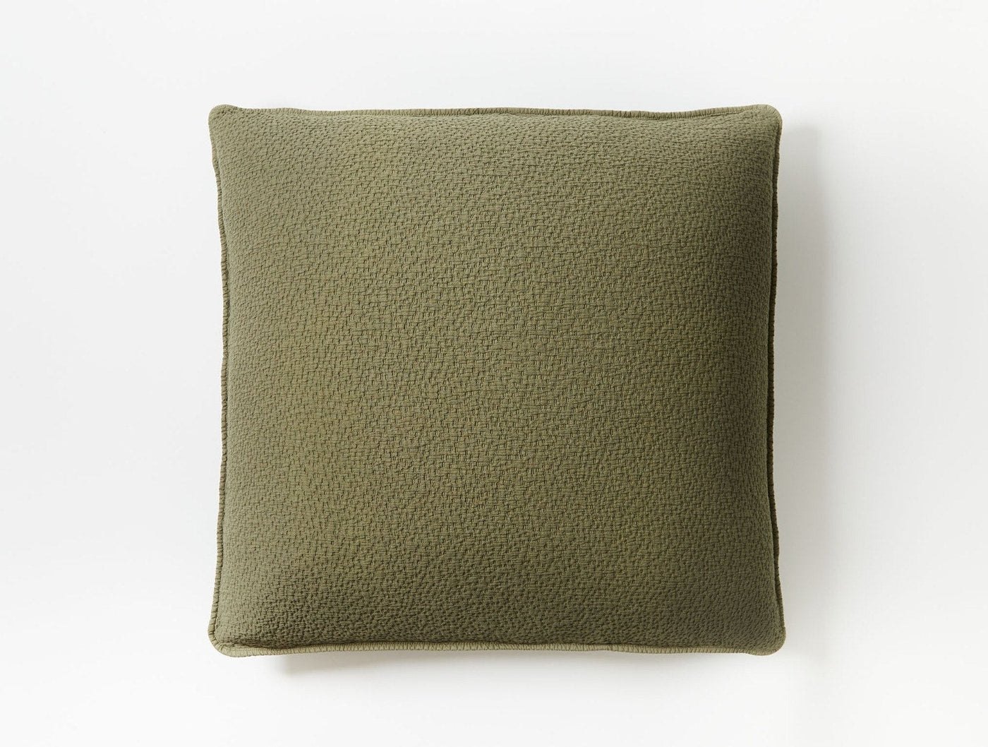 Close-up of Coyuchi Cascade Matelassé sham in olive, showing textured surface and piped edge.