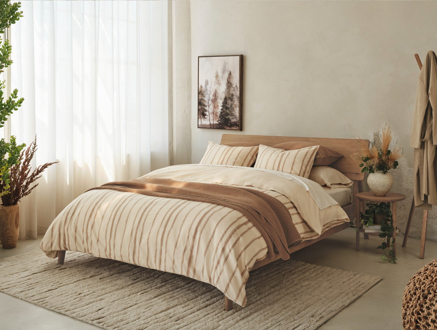 Coyuchi Cazadero Stripe duvet cover styled on a bed in a warm, natural bedroom setting.