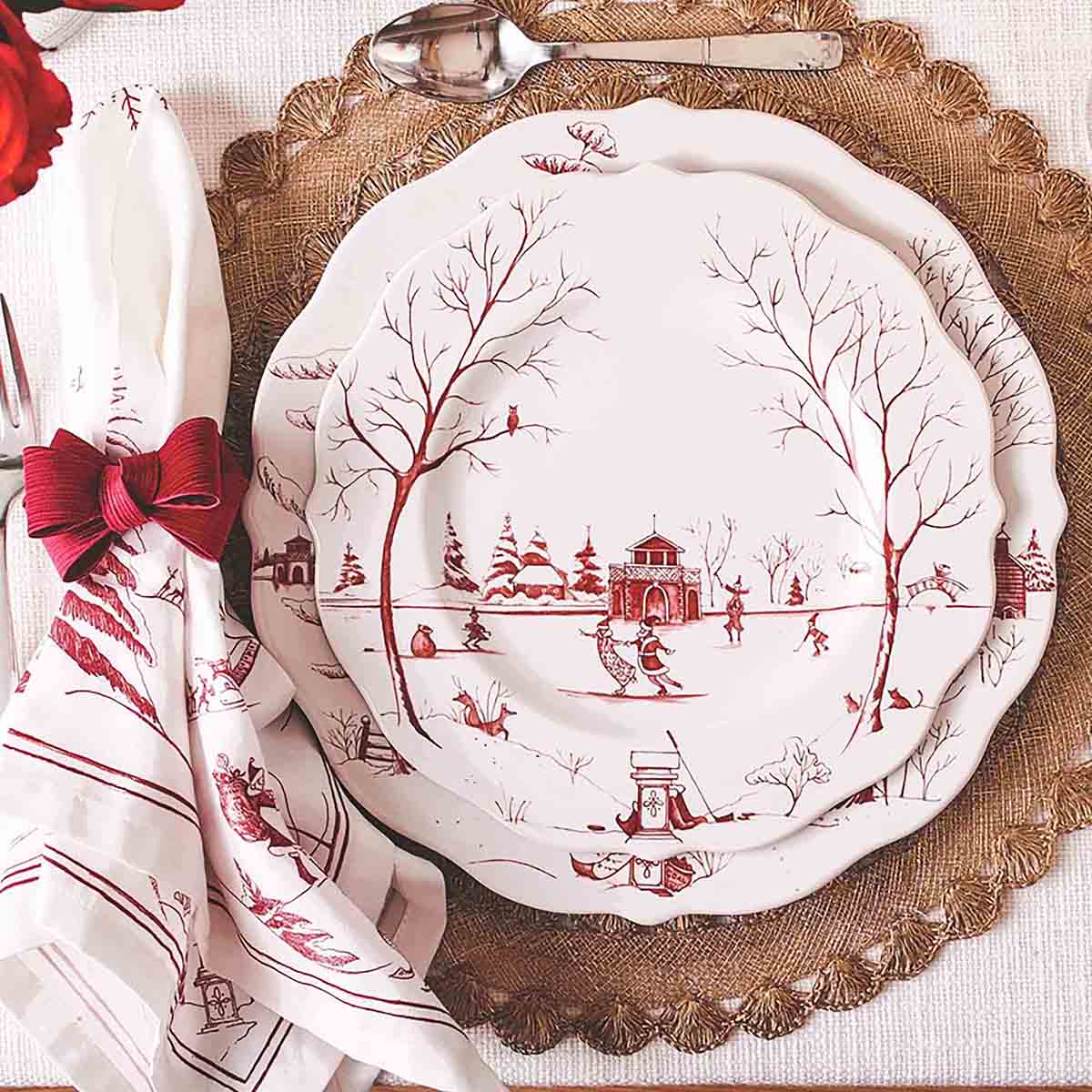 Ruby Winter Frolic napkin beside ruby plates on a gold charger
