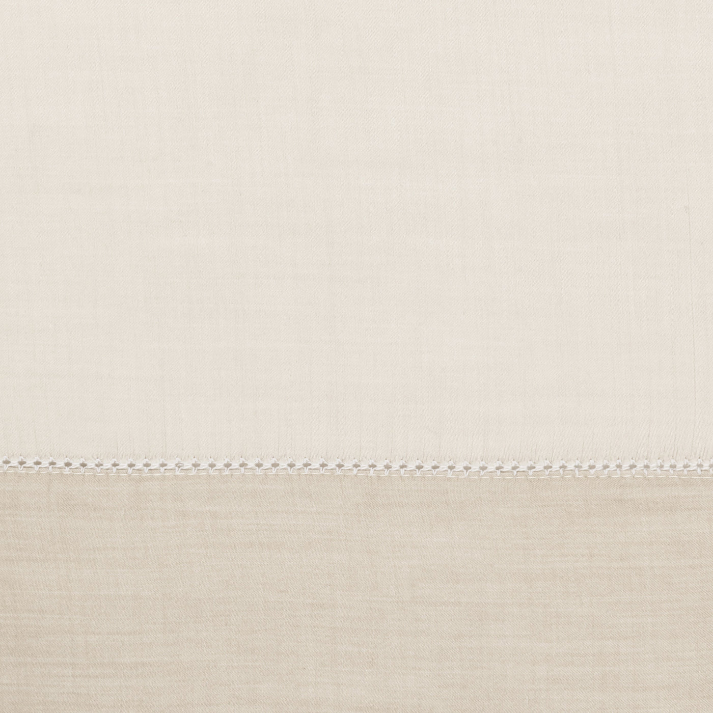 Close-up of ivory linen fabric with contrast hemstitch border detail.