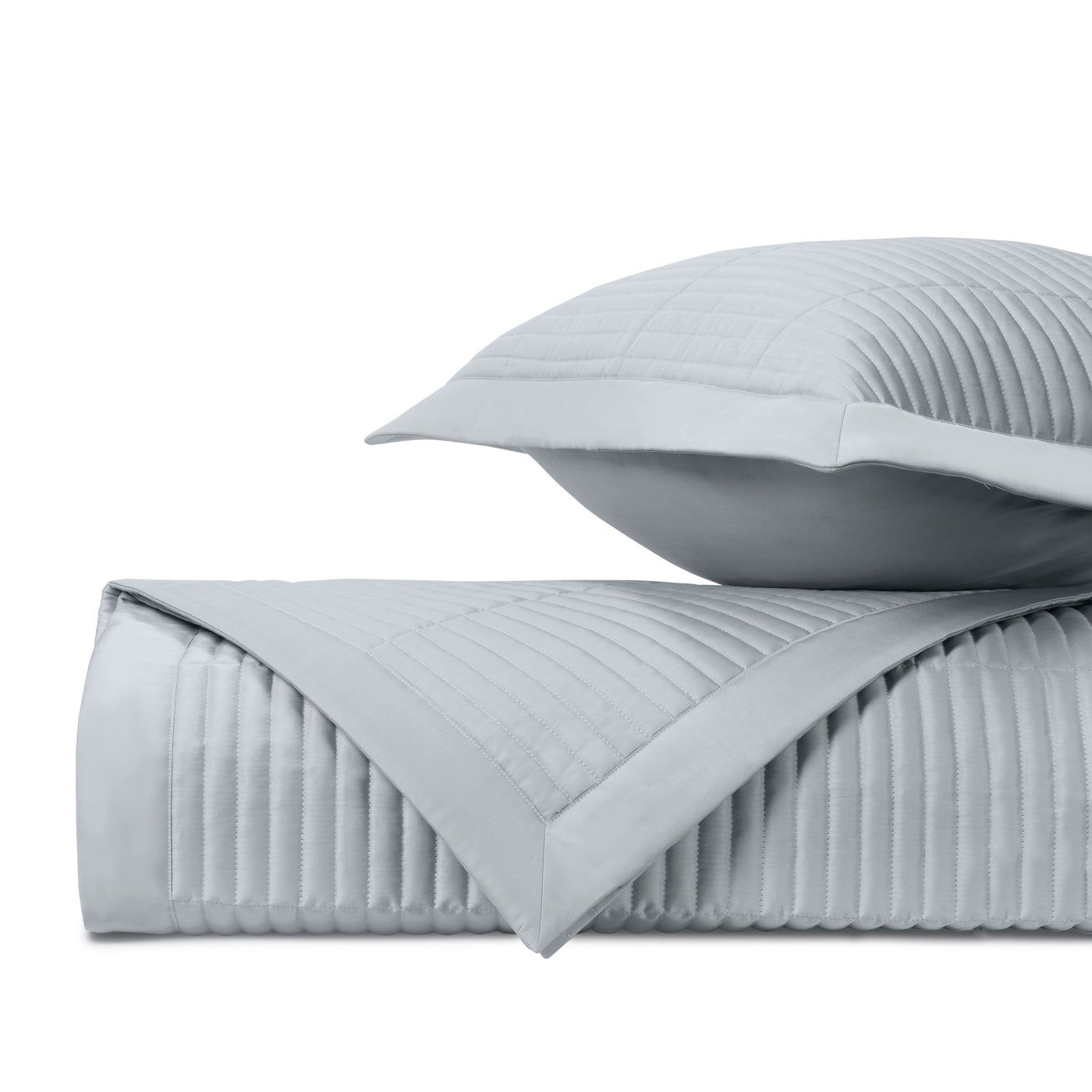 Close-up of channel-quilted silver fabric with parallel stitched rows and contrast border.