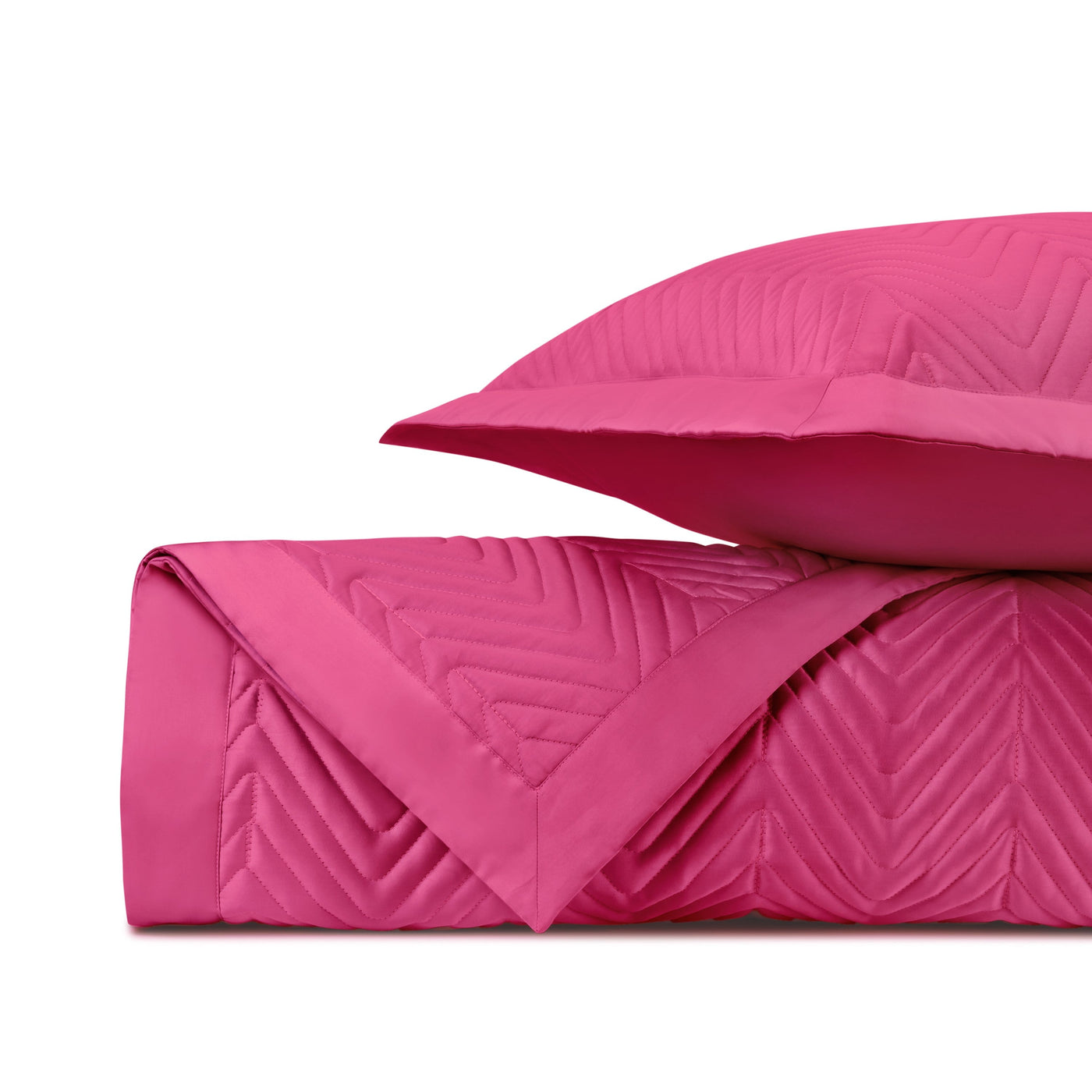Close-up of fuchsia quilted fabric with chevron stitching pattern, folded with matching sham.