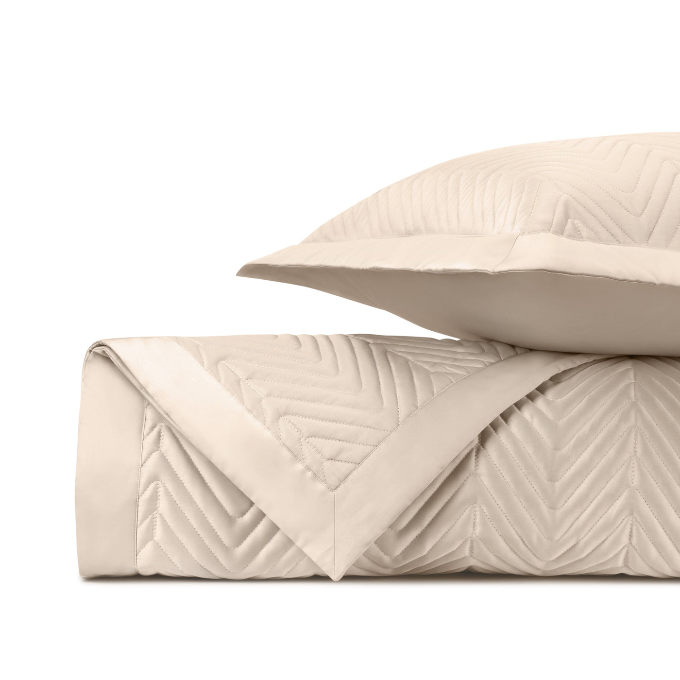 Close-up of ivory quilted satin with chevron stitching pattern, folded with matching sham.