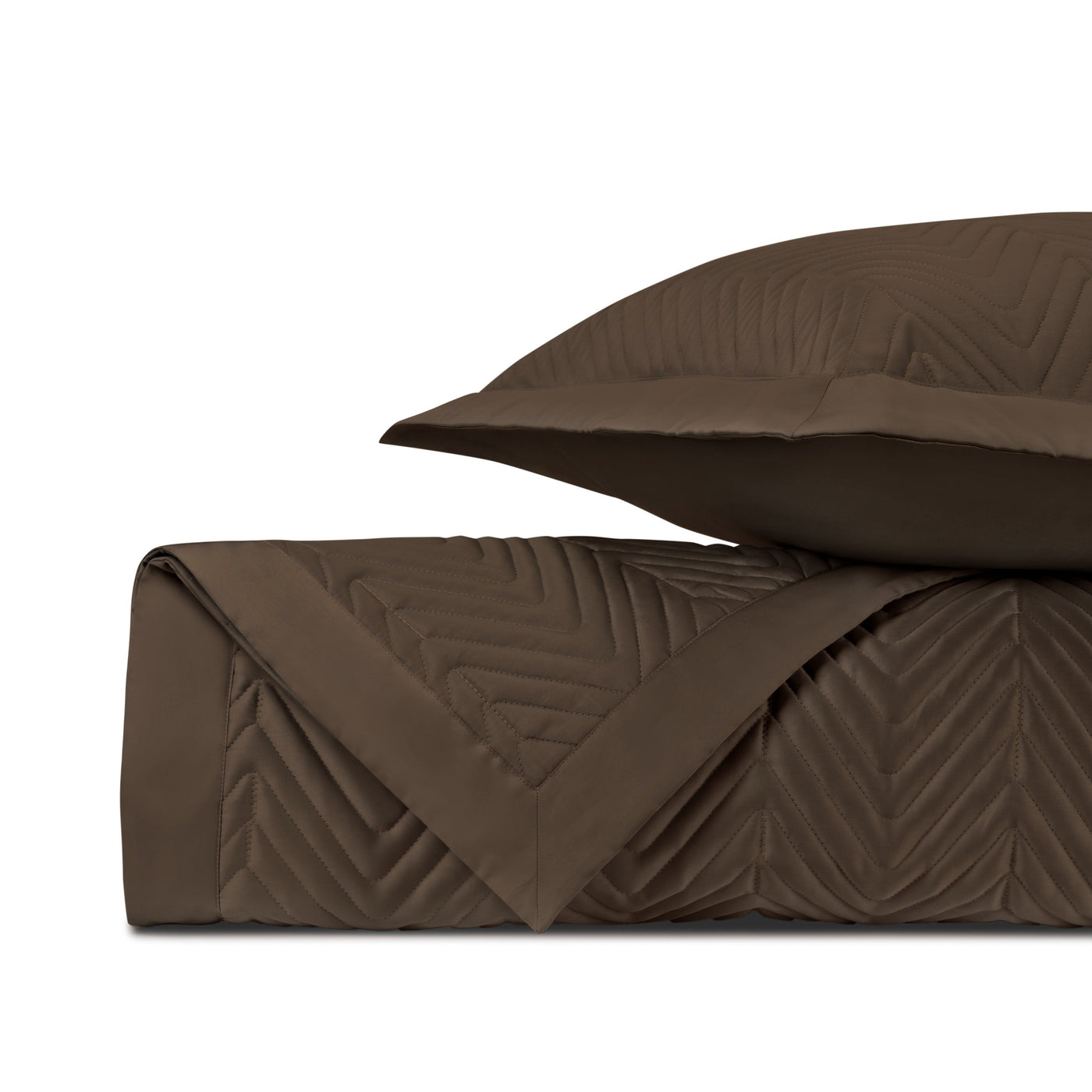 Chocolate quilted coverlet and sham with chevron stitching, folded and stacked.