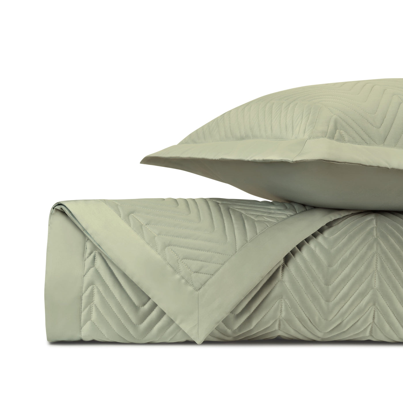 Close-up of sage green quilted satin fabric with chevron stitching pattern.