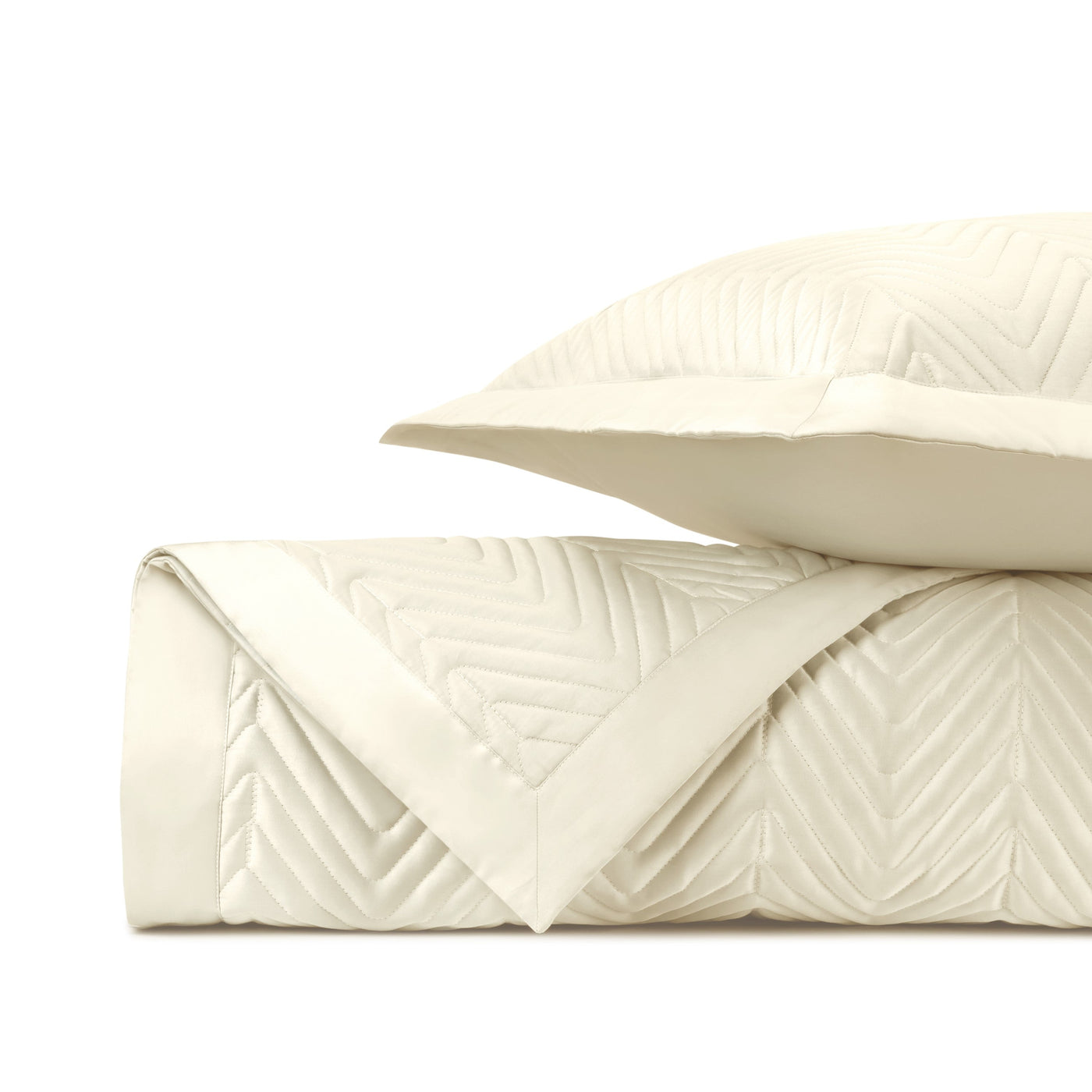 Close-up of ivory quilted satin with chevron stitching pattern and contrast border trim.