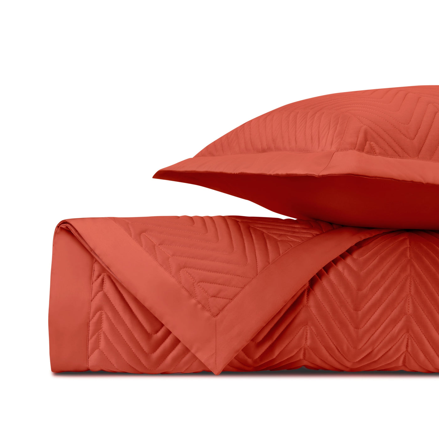 Close-up of coral quilted fabric with chevron stitching pattern.