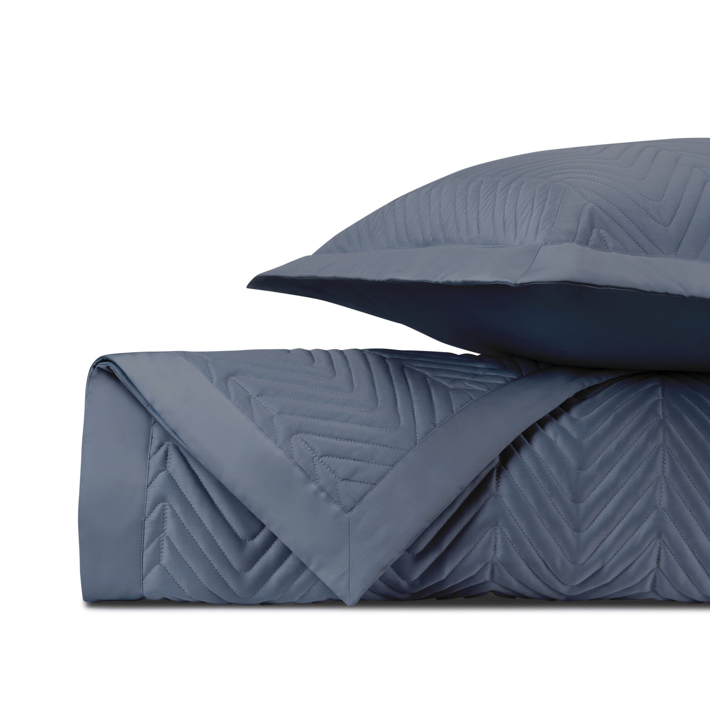 Close-up of slate blue quilted fabric with chevron stitching pattern and navy reverse.
