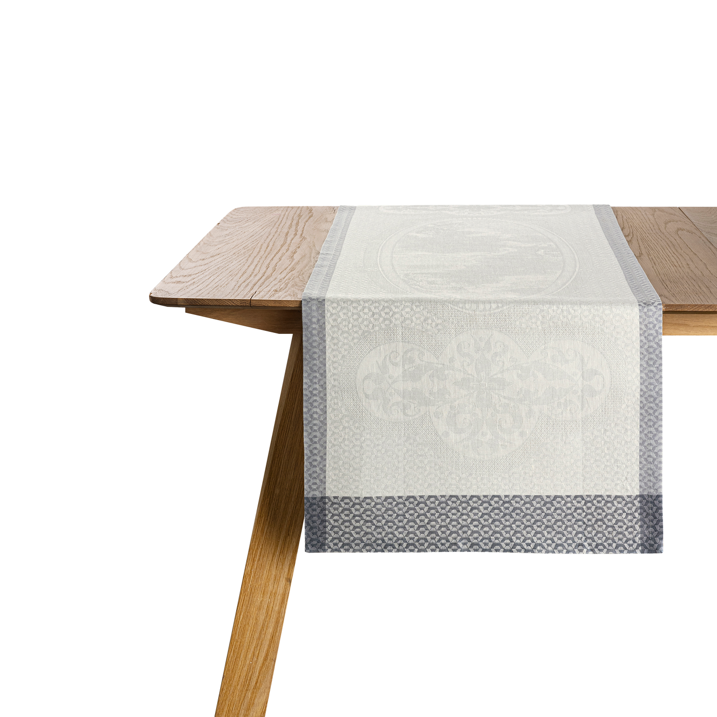 Le Jacquard Français Évasion Céleste ivory jacquard table runner with slate border on oak table.