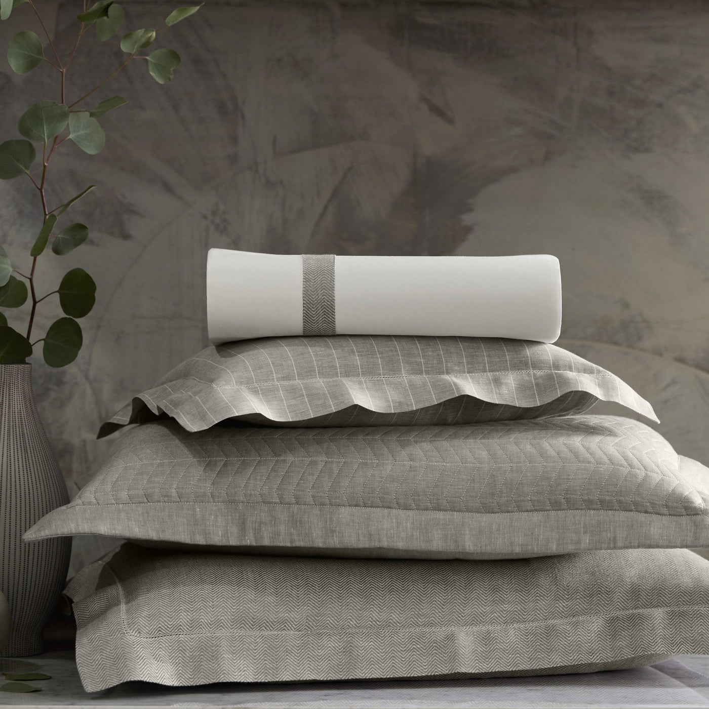Close-up stack of Home Treasures Chester grey linen pillow shams with subtle grid weave.