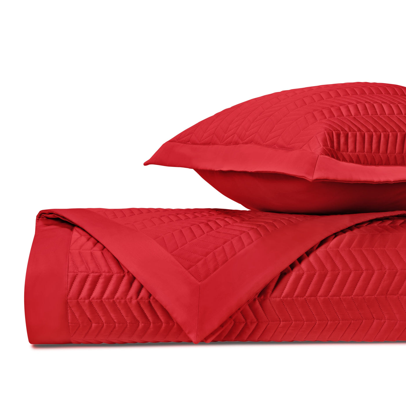 Close-up of crimson quilted chevron texture on folded coverlet and sham.