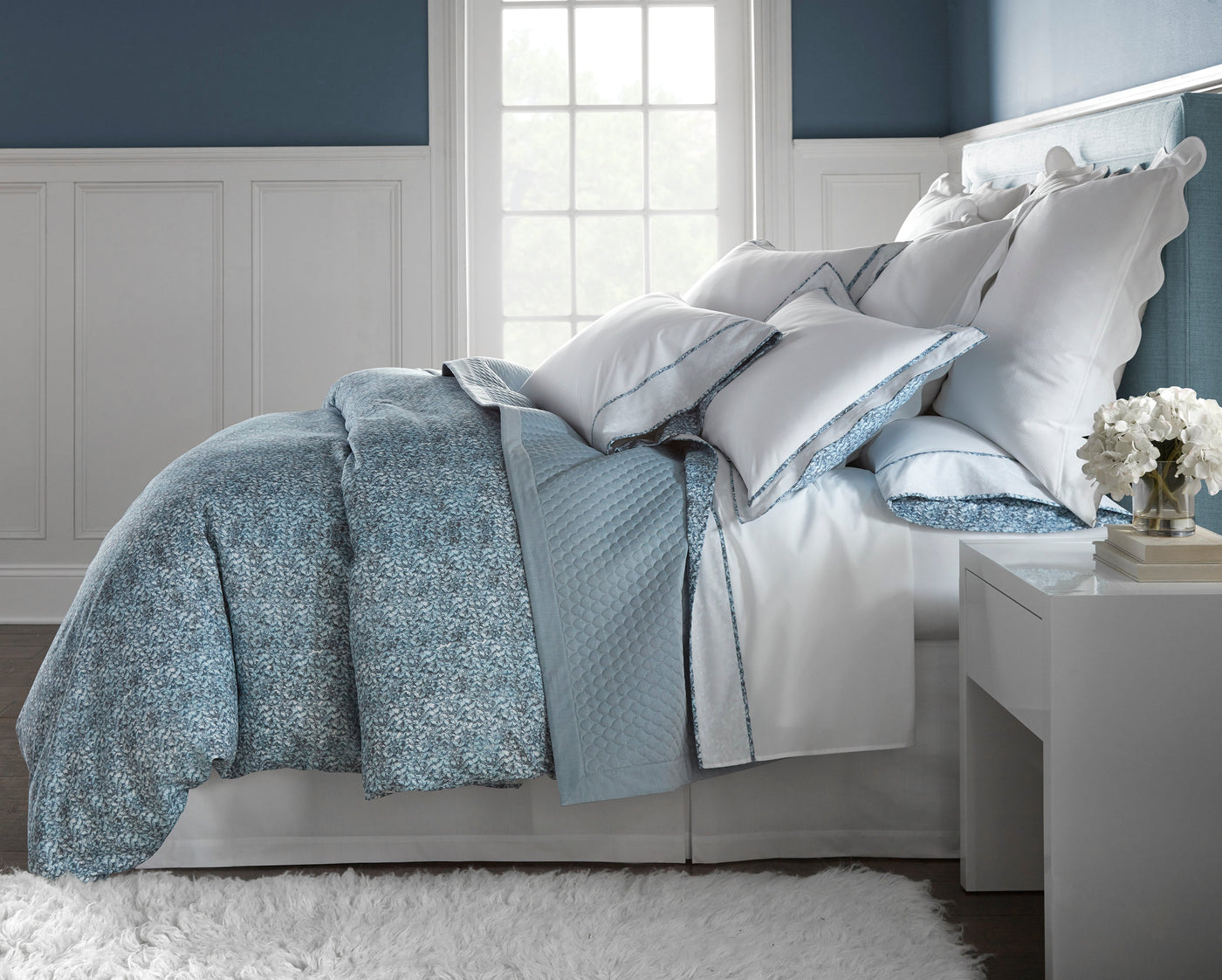 Bedroom styled with Clara bedding in soft blue floral and pearl white with scalloped pillow shams.