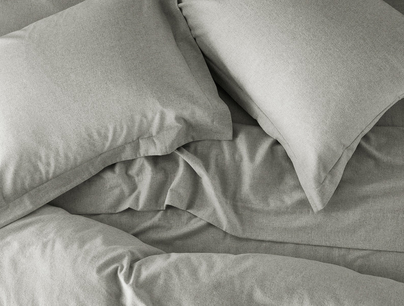 Sage flannel duvet and pillowcases styled on a bed, showing soft brushed texture.